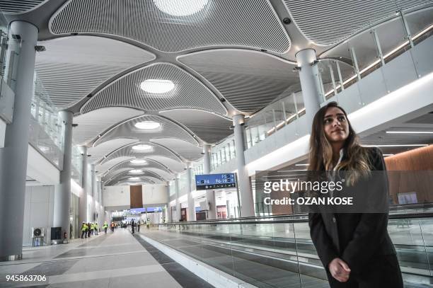 An employee greets guests visiting the terminal building still under construction at the Istanbul New Airport on April 13 during press tour in...