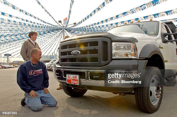 Sales associate Chris Stephens, rear, shows a F550 Ford truck to David Carter, kneeling, at the Jim Skinner Ford Dealership in Birmingham, Alabama...