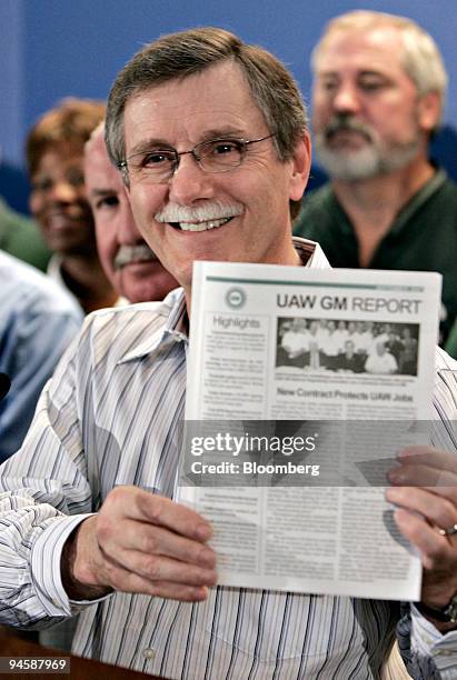 Ron Gettelfinger, president of the United Auto Workers, displays a copy of the union's tenative contract with General Motors during a news conference...