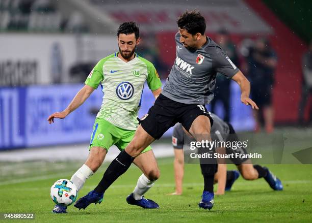 Yunus Malli of Wolfsburg and Rani Khedira of Augsburg battle for the ball during the Bundesliga match between VfL Wolfsburg and FC Augsburg at...