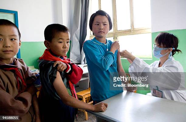School children roll up their sleeves to receive injections of the Hepatitis B vaccine in Ledu, Qinghai, China, on Monday, Sept. 17, 2007. Run by the...