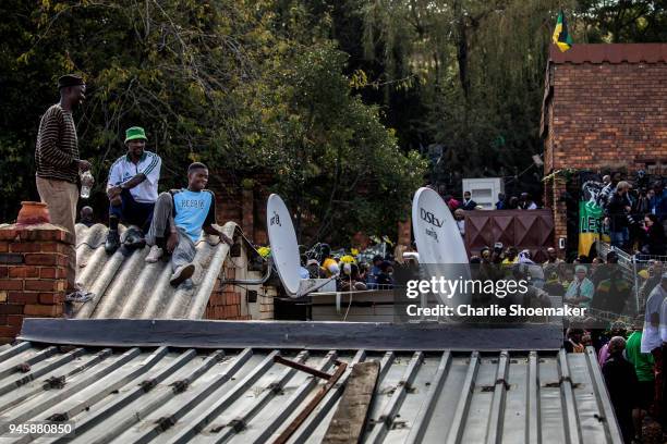People watch from roof tops as the body of Winnie Mandela is returned to her home in Soweto the day before the funeral for the anti-apartheid icon on...
