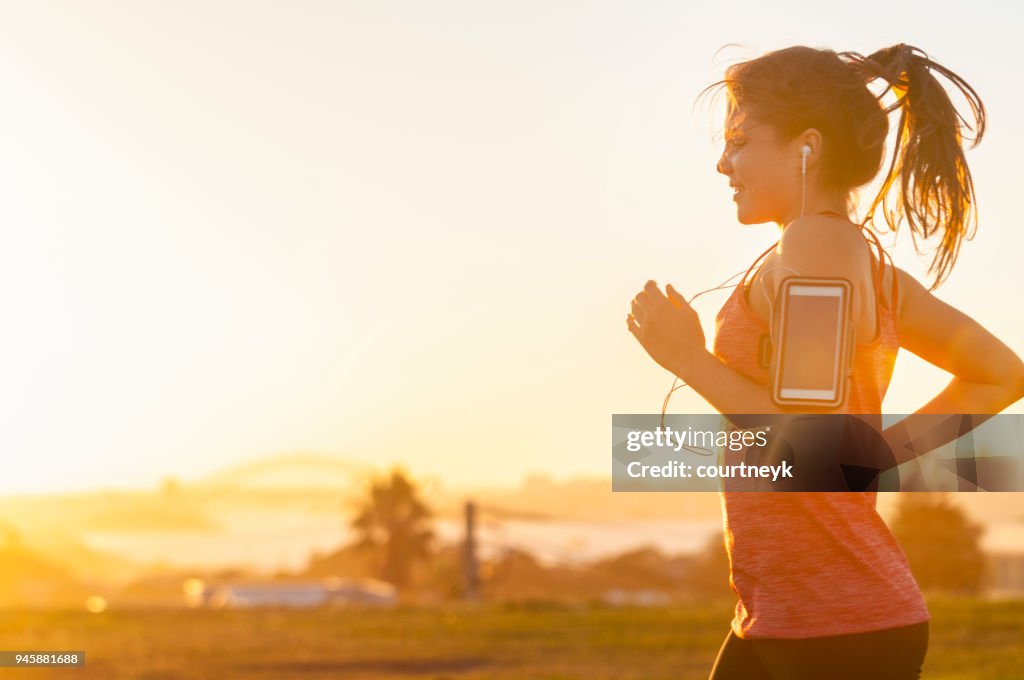 Woman running with mobile phone on her arm.