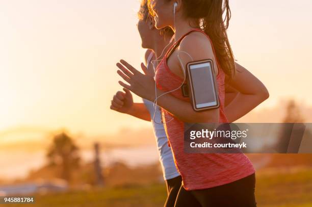 two women running together in the park. - sydney racing stock pictures, royalty-free photos & images