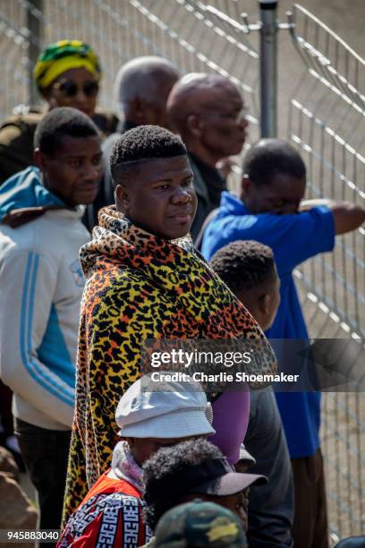 People look on as the body of Winnie Mandela is returned to her home in Soweto the day before the funeral for the anti-apartheid icon on April 13,...