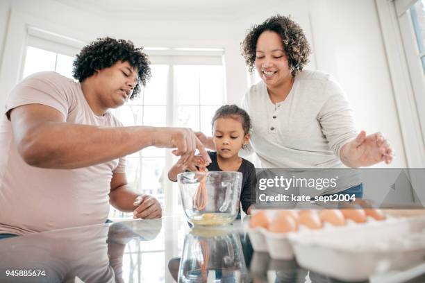 father and mother teaching their daughter how to bake - wife beater stock pictures, royalty-free photos & images