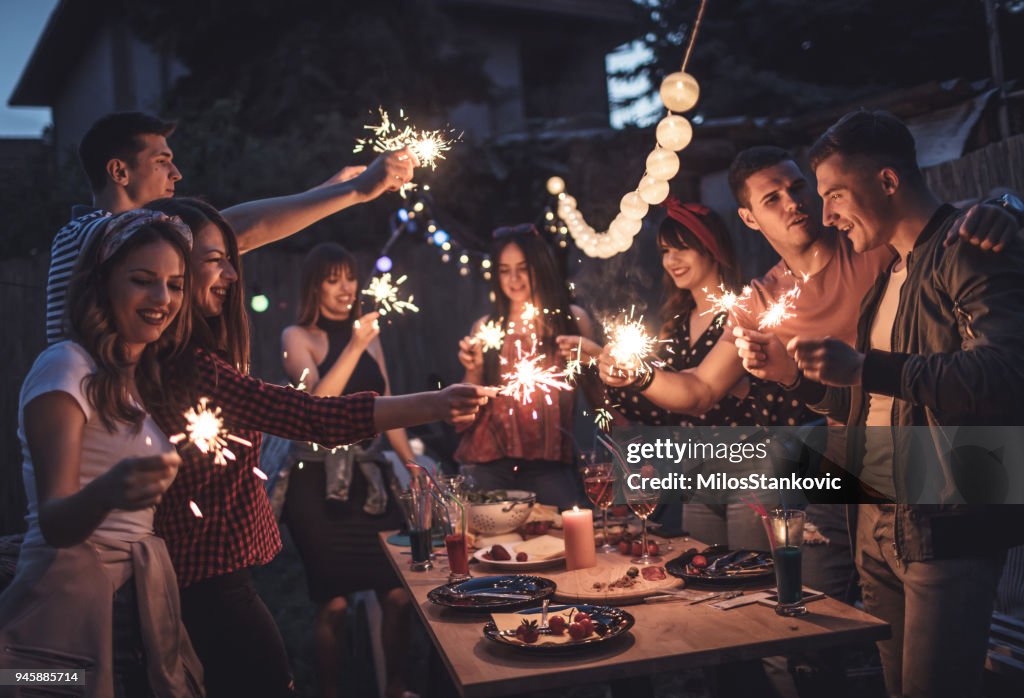 Group of friends having dinner party in backyard