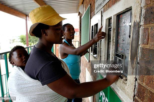 Women buy pre-paid electricity from a vending machine in Olifantsfontein, a township north of Johannesburg, South Africa, Saturday, Jan. 27, 2007....