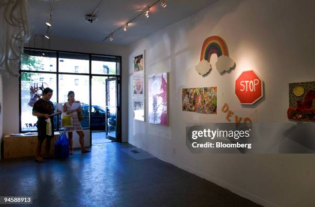 Gallery-goers look at works of art on display at Smith-Stewart gallery, located at 53 Stanton Street on the Lower East Side of New York, Saturday,...