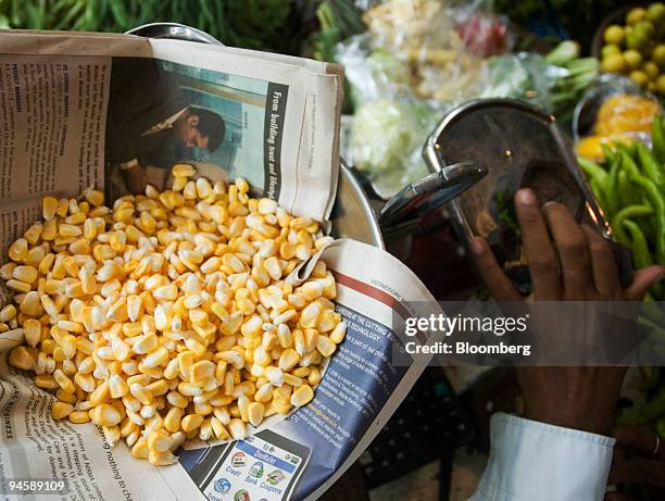 Vegetable vendor weighs fresh corn in Mumbai, India, on Monday, July 9, 2007. Farmers in India, the world's second-biggest vegetable oil buyer,...