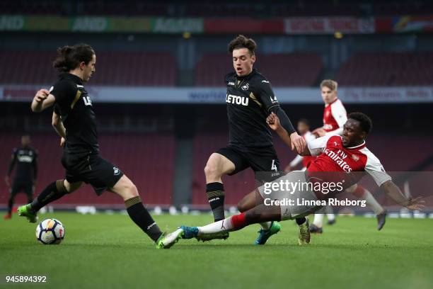 Tolaji Bola of Arsenal, Jack Evans of Swansea City and Aaron Evans of Swansea City battle for possession during the Premier League 2 match between...