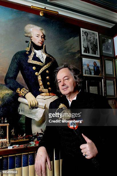 Author Gonzague Saint Bris poses in front of a portrait of the Marquis de La Fayette holding the Marquis' sword, in his apartment, in Paris, France,...