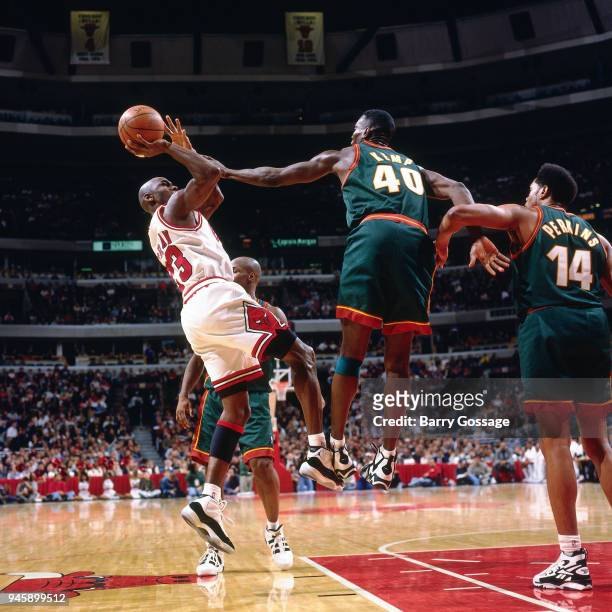 Michael Jordan of the Chicago Bulls shoots the ball over Shawn Kemp of the Seattle SuperSonics during the game on January 10, 1996 at the United...
