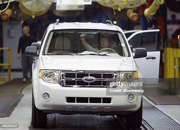 An employee adjusts the rear view mirror as she prepares to drive a car off the assembly line at the Ford Motor Co. Kansas City Assembly Plant in...