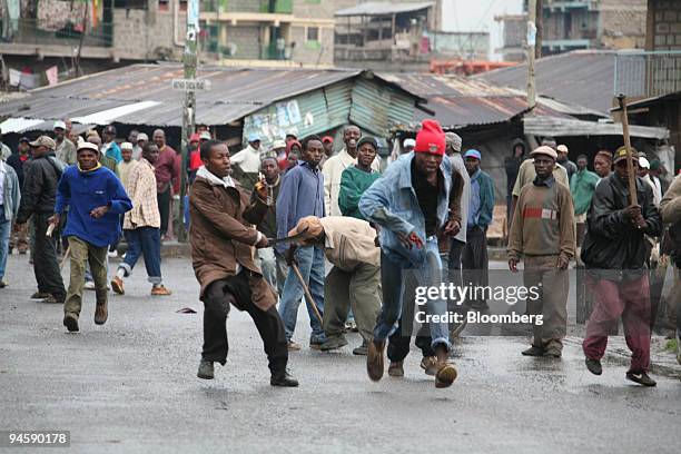 Man, thought to be an opposition supporter, is chased and hacked at with a machete by supporters of Kenya's President Kibaki in the Huruma area of...