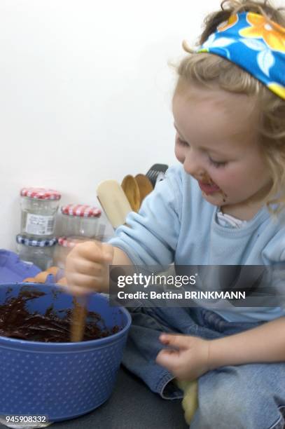 FILLETTE DE 3 ANS PREPARANT UN GATEAU AU CHOCOLAT.