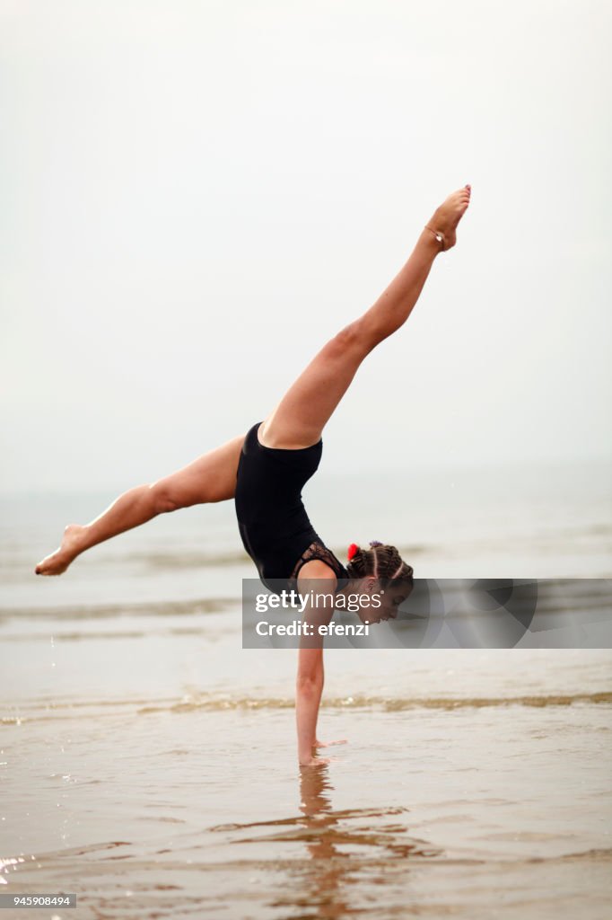 Beautiful Young Female Gymnast Doing Splits On Beach
