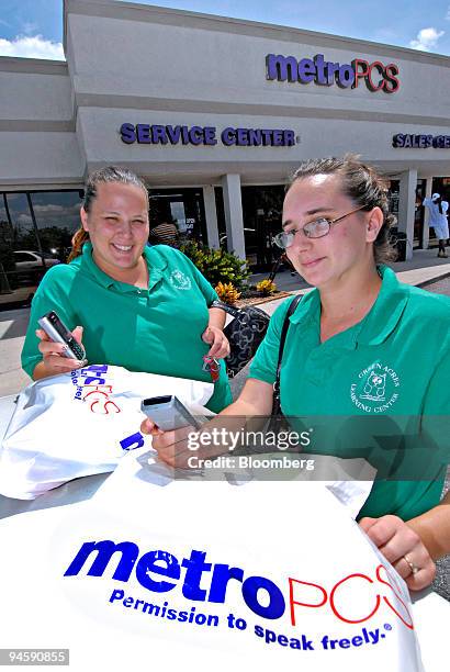 Nicole Soto, left, and Selena Epstein display their newly purchased MetroPCS mobile phones outside the MetroPCS store in Lake Worth, Florida, U.S.,...