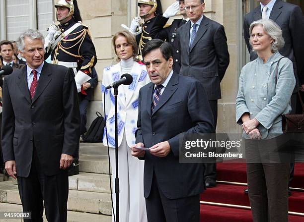 Outgoing French Prime Minister Dominique de Villepin, left, and his wife, Marie-Laure, listen as the new Prime Minister Francois Fillon, center,...