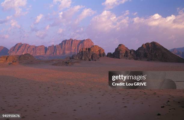 Desert du Wadi Rum en Jordanie Falaises de gr?s rouges JORDANIE DESERT DU WADI RUM SOIR NUAGES ROSES FALAISES ROCHEUSES Desert du Wadi Rum en...