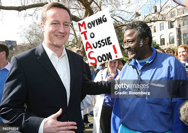 David Cameron, the U.K. Conservative Party leader, left, talks with Dr. Olusola Oni an orthopaedic surgeon from Leicester Hospital during a doctors...