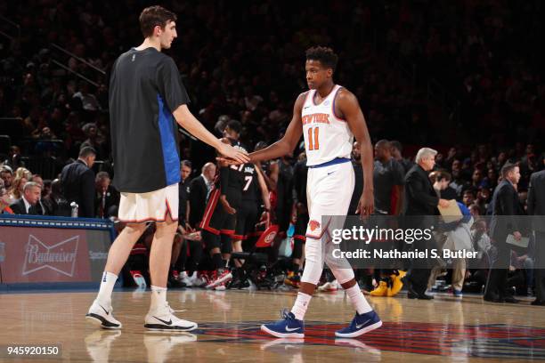 Frank Ntilikina of the New York Knicks high-fives Luke Kornet of the New York Knicks during the game against the Miami Heat on April 6, 2018 at...