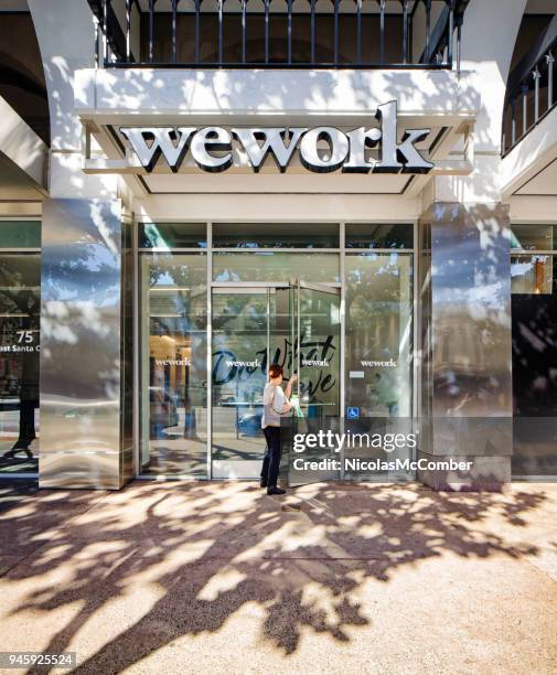 wework san jose main entrance with female walking in - daily life in silicon valley stock pictures, royalty-free photos & images