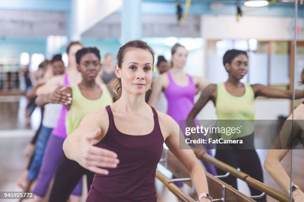 women doing barre workout together at modern gym - pike position stock pictures, royalty-free photos & images