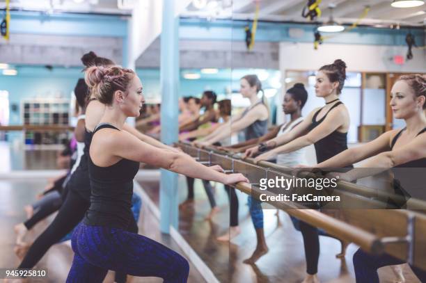 multiethnic group of women do a barre workout together in a modern health club - pike position stock pictures, royalty-free photos & images