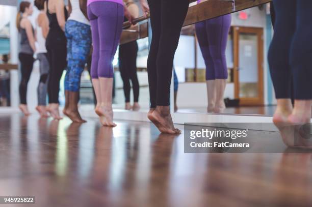 multiethnic group of women do a barre workout together in a modern health club - pike position stock pictures, royalty-free photos & images