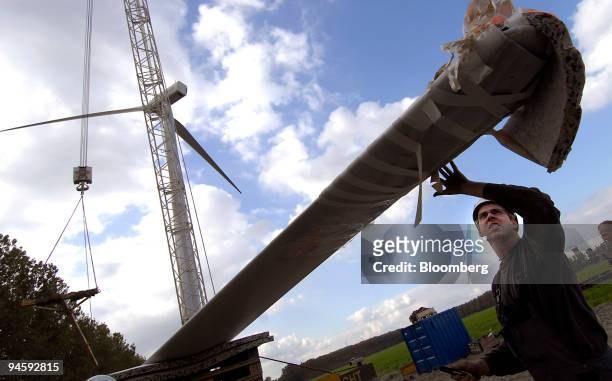 Construction worker examines a blade at a wind powered electricity generator farm near Terneuzen, The Netherlands on Wednesday, Oct. 10, 2007. Wind...