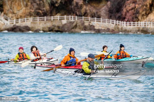 a group of men and women sea kayaking - sea kayaking imagens e fotografias de stock