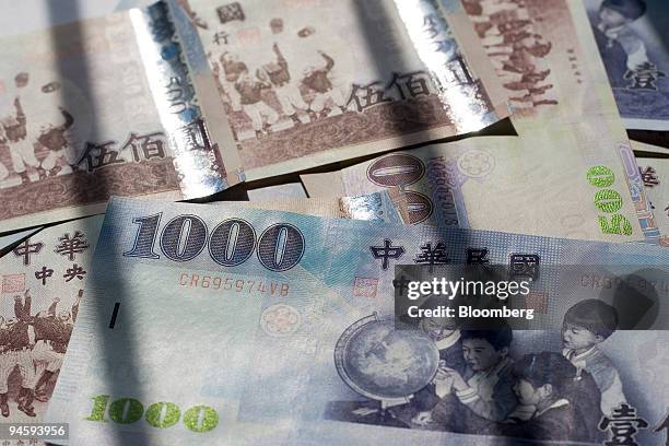 Taiwanese dollar bills in different denominations are arranged for a photograph in Taipei, Taiwan, on Wednesday, May 2, 2007. Taiwan's dollar slipped...