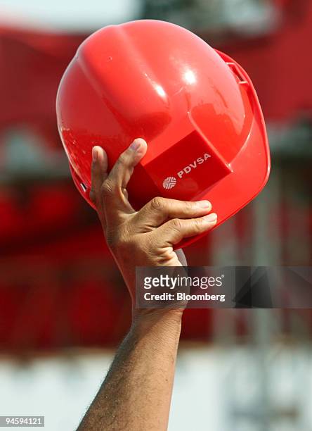 Supporter of Venezuelan President Hugo Chavez waves a helmet of PDVSA during a speech by the President at the Jose Antonio Anzotegui oil complex in...