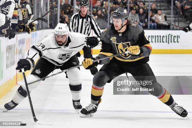 Nate Thompson of the Los Angeles Kings and Colin Miller of the Vegas Golden Knights skate to the puck in Game One of the Western Conference First...
