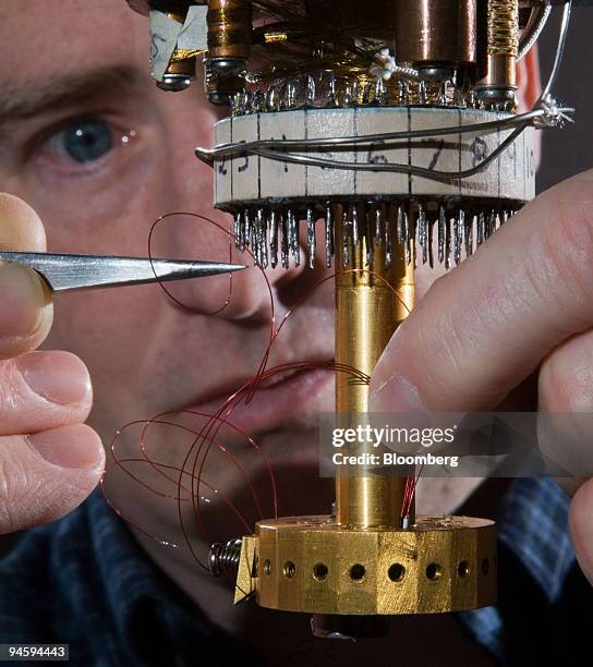 Engineer Scott Courts installs wiring onto terminals of a dilution refrigerator at Lake Shore Cryotronics in Westerville, Ohio, Friday, April 2007....