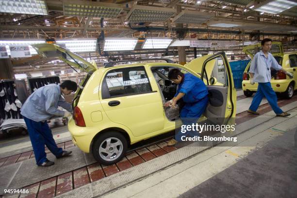 Chinese workers add components to a Chery QQ compact car on an assembly line in the Chery Automotive Co. Ltd. Factory in Wuhu, Anhui Province, China,...
