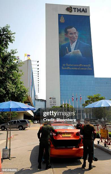 Security staff search a car as it arrives in front of the headquarters of Thai Airways International Plc. In Bangkok on Thursday, Jan. 25, 2007. The...