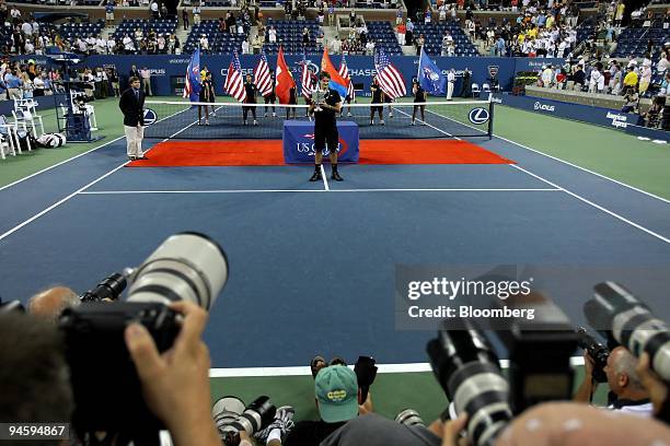 Roger Federer of Switzerland poses with his championship trophy after defeating Novak Djokovic of Serbia in their men's singles final match on day...