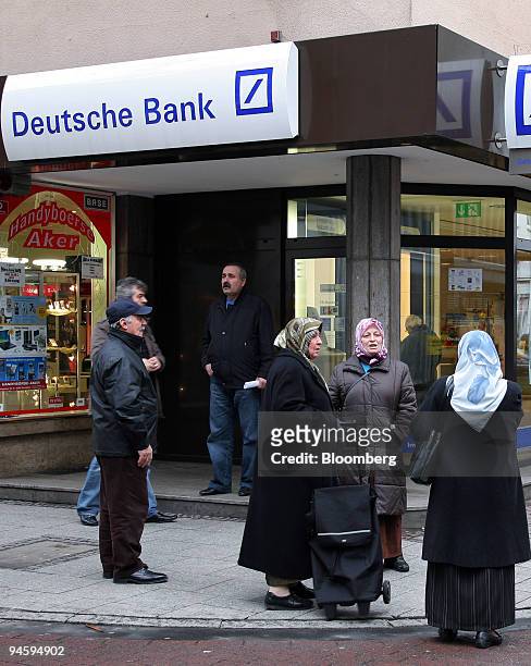 Turkish Pedestrians stand outside at a Deutsche Bank branch in Frankfurt-Hoechst, Germany, on Wednesday, Jan. 16, 2008. Deutsche Bank AG, Germany's...