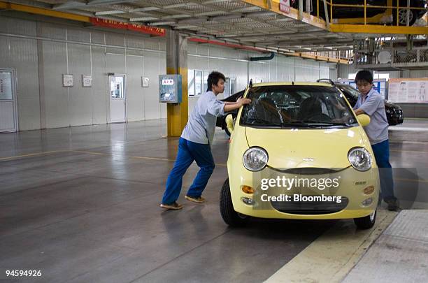 Workers push a Chery QQ compact car to the assembly line in the Chery Automotive Co. Ltd. Factory in Wuhu, Anhui Province, China, on Wednesday, May...