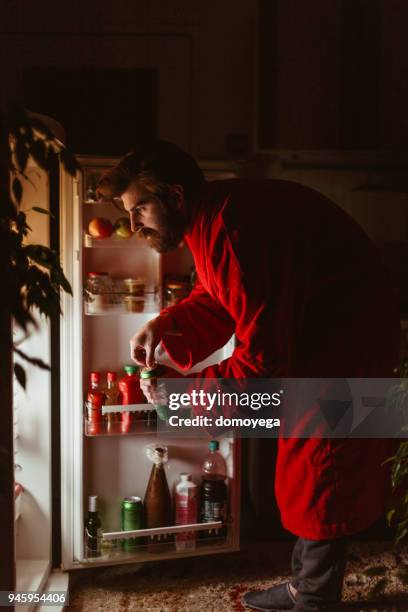 mann mit schlechten gewohnheiten vor dem kühlschrank spät in die nacht - beer fridge stock-fotos und bilder