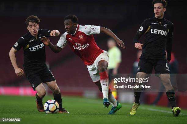 Tolaji Bola of Arsenal takes on Daniel James and Jack Evans of Swansea during the match between Arsenal U23 and Swansea U23 at Emirates Stadium on...