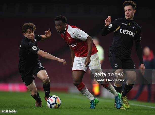 Tolaji Bola of Arsenal takes on Daniel James and Jack Evans of Swansea during the match between Arsenal U23 and Swansea U23 at Emirates Stadium on...