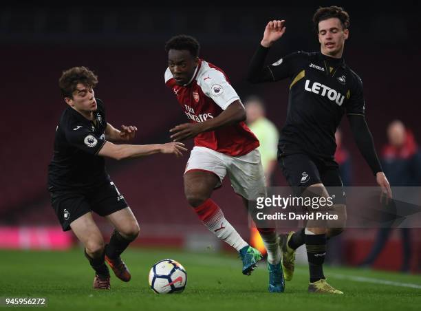 Tolaji Bola of Arsenal takes on Daniel James and Jack Evans of Swansea during the match between Arsenal U23 and Swansea U23 at Emirates Stadium on...