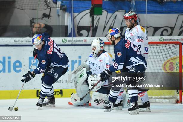 Jason Jaffray of EHC Muenchen plays the puck in front of Goalkeeper Petri Vehanen of Berlin during the DEL Playoff Final Game 1 between EHC Red Bull...