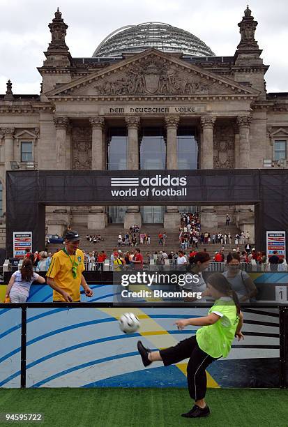 Visiting child kicks a soccer ball in the Adidas World of Football promotional park in front of the Reichstag, or German parliament building, in...