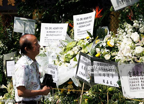 Member of the public looks at floral trubutes for Henry Fok displayed at the Hong Kong Funeral in Chai Wan, Hong Kong, on Tuesday, Novembr 7, 2006....