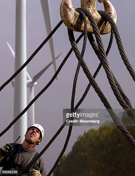 Construction worker supervises the hoisting of a turbine at a wind powered electricity generator farm near Terneuzen, The Netherlands on Wednesday,...
