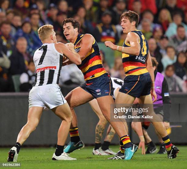 Adam Treloar of the Magpies wrestles with Darcy Fogarty of the Crows during the round four AFL match between the Adelaide Crows and the Collingwood...